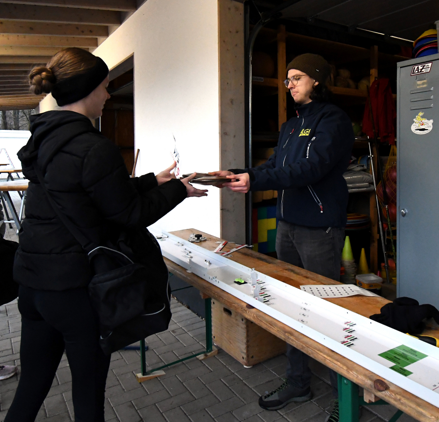 LAZ-Sportwart Florian Wendt &uuml;berreicht einer Sportlerin Disken, die er gerade mit dem neuen Ger&auml;te-Mess- und Pr&uuml;fset des Vereins auf ihren ordnungsgem&auml;&szlig;en Zustand untersucht hat.                             Die Anschaffung des Pr&uuml;fsets konnte das LAZ Soest mit einer finanziellen Zuwendung der "Freunde der Leichtathletik" realisieren. Foto: Bottin